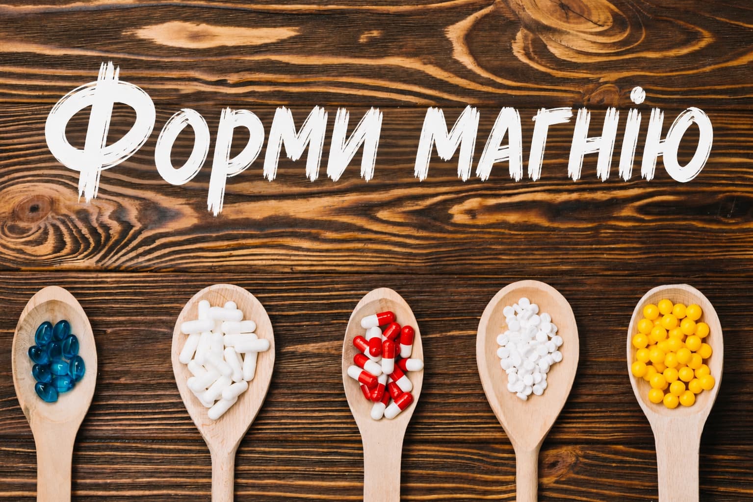 Форми магнію в капсулах і таблетках на дерев'яному тлі